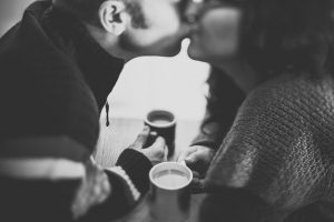 Paar küsst sich beim Kaffee trinken
