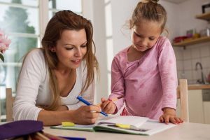 Mutter hilft Kind bei Hausaufgaben