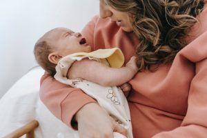 Mutter hält schreiendes Baby auf Arm