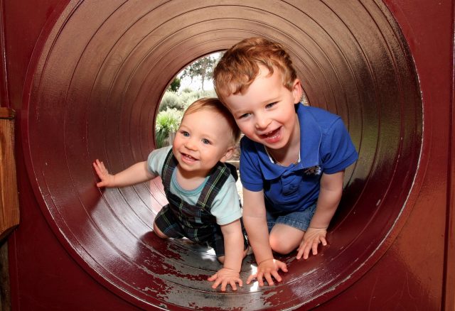 Zwei Jungen in Spieltunnel lachend