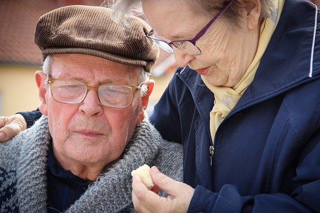 Ältere Frau kümmert sich um älteren Mann