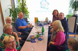 Besucherinnen und Besucher des Spieletreffs sitzen an einem Tisch und spielen zusammen.