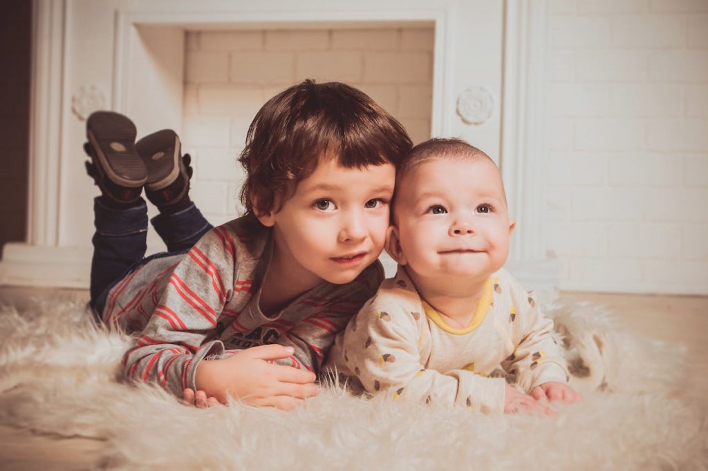 Kind und Baby posieren für Foto