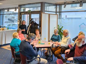 Ehrenamtliche beim Ehrenamtstreffen sitzen an Tischen