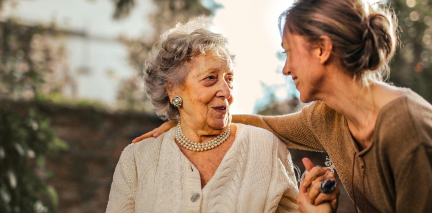 Frau umarmt ältere Frau