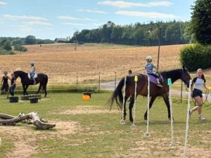 Kinder reiten auf Pferden über Parcours