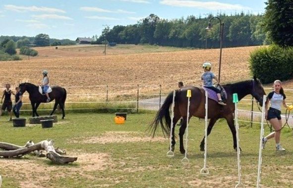 Kinder reiten auf Pferden über Parcours