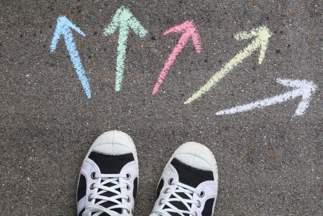 Schuhe auf Boden davor bunte Pfeile
