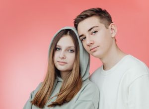 Junge und Mädchen vor rosa Hintergrund