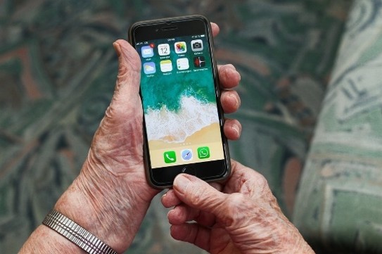 Ältere Person hält Smartphone in den Händen