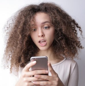 Mädchen erschrocken am Smartphone