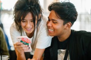 Mädchen und Junge schauen in Smartphone