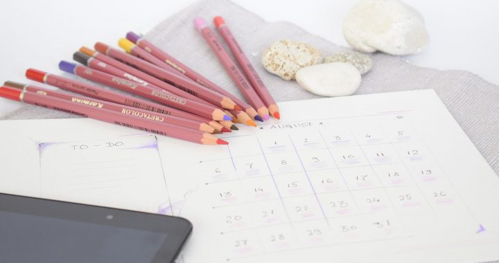 Kalender und Buntstifte auf Tisch