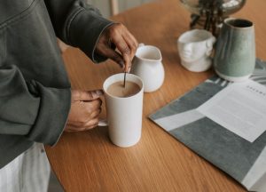 Frau rührt Kaffee in Kaffeetasse um