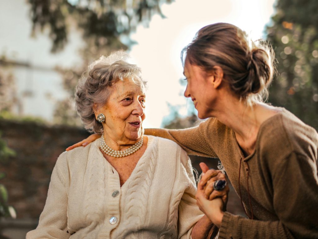 Frau umarmt ältere Frau