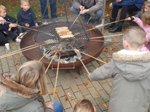 Kinder grillen Stockbrot am Feuer