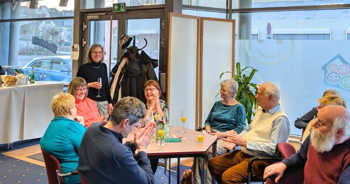 Ehrenamtliche beim Ehrenamtstreffen sitzen an Tischen